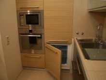 Дизайн і схема кутової кухні з холодильником (43 фото): огляд кухонних гарнітурів з пеналом і з вбудованим холодильником. Варіанти розташування біля входу і вікна