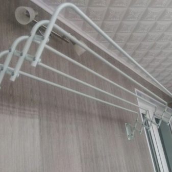 Настінні сушарки для білизни на балкон (37 фото): вибираємо розсувні і доладні балконні вішалки для сушіння, особливості кріплення на стіну висувних систем