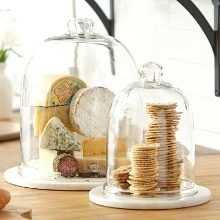 Тарілки з кришкою: металевий клош на підставці для подачі гарячих страв, прозорі скляні баранчики та інші види посуду
